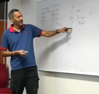 Palani Murugappan teaching at a whiteboard during a training session